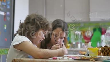 胖女孩画画。 孩子们画一幅画。 胖女孩画慢动作视频。 孩子们在室内画画